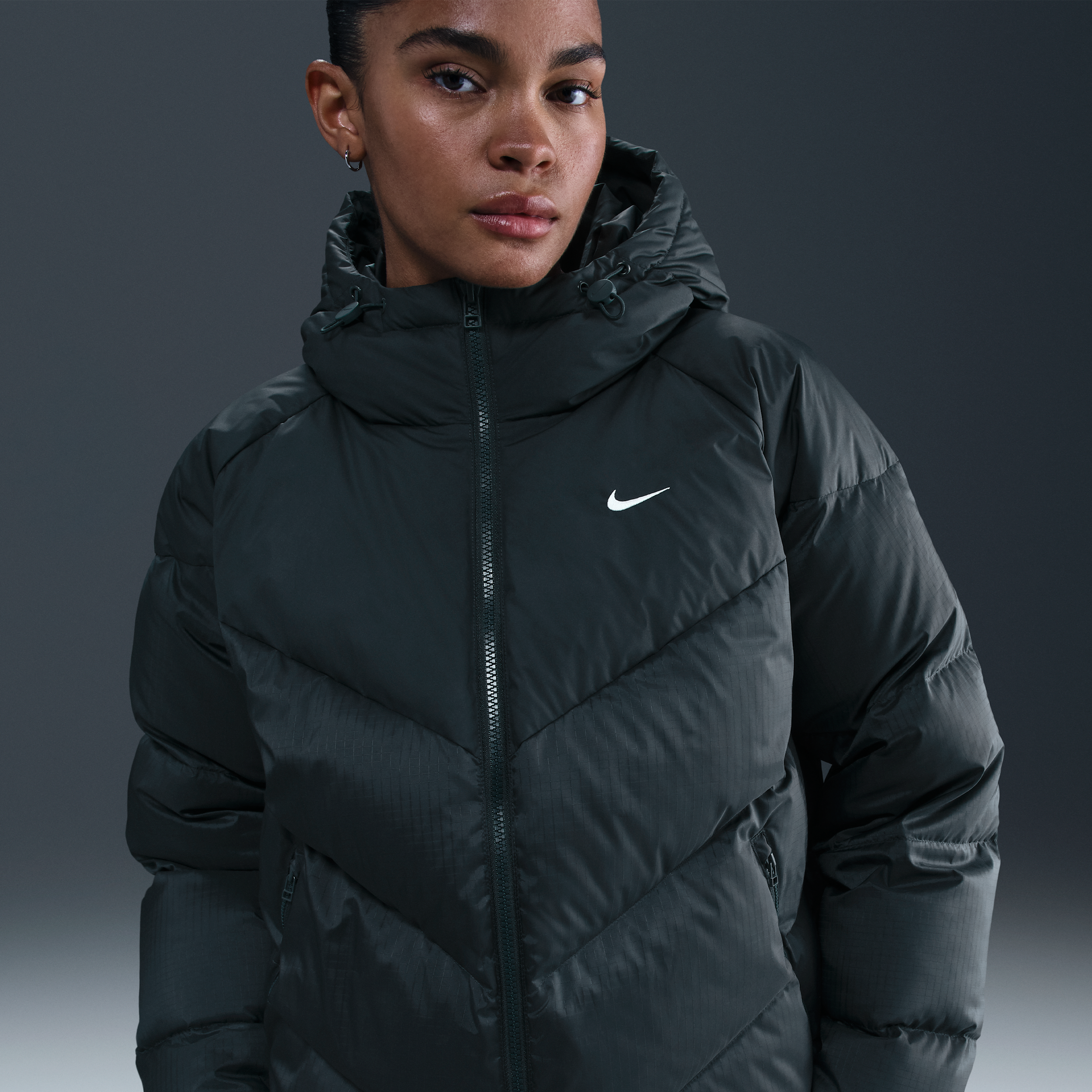 Nike Sportswear Windpuffer Storm-FIT gewatteerd jack met ruimvallende pasvorm en capuchon voor dames - Groen